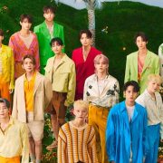SEVENTEEN strikes a powerful pose on the cover of their FML album, radiating charisma and defiance against a backdrop of vibrant neon lights