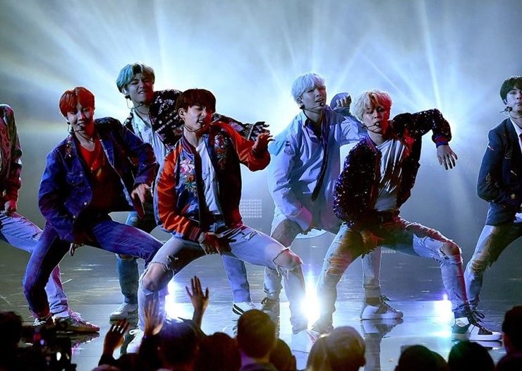 BTS performing live on stage to a cheering crowd