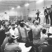 Johnny Cash strums his guitar while performing onstage at Folsom State Prison