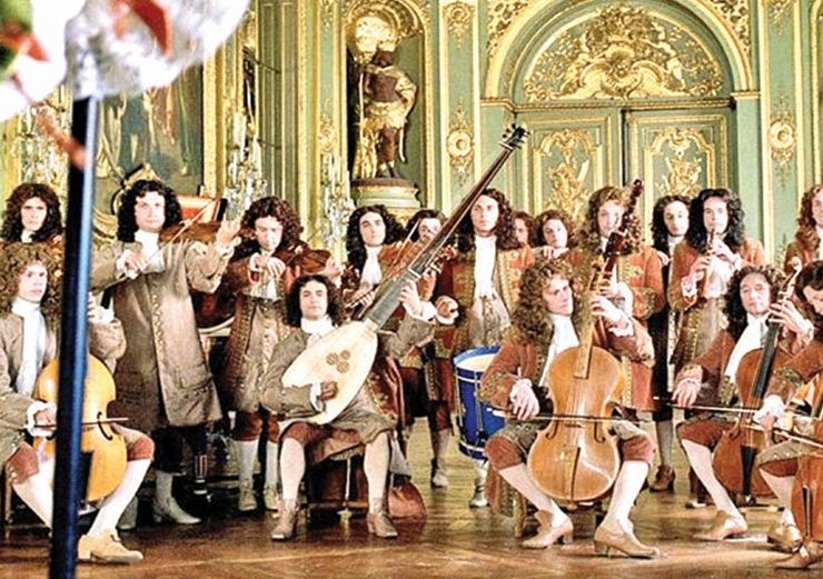 An ornate violin resting on sheet music with Baroque era motifs